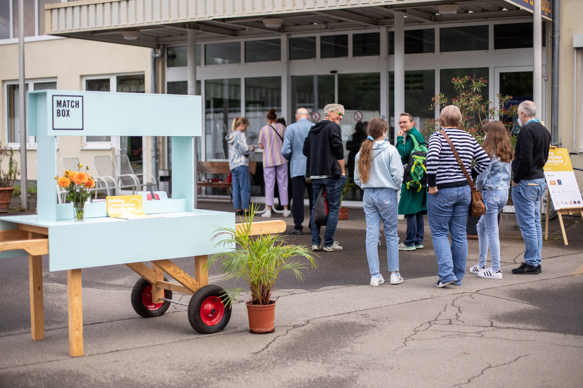 Ein Infostand, Menschen stehen in einer Schlange | © Arthur Bauer