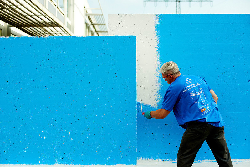 Person streicht eine Wand in blauer Farbe  | © MRN GmbH