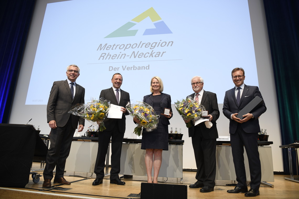 fünf Personen auf der Bühne vor dem MRN-Logo mit Blumen in der Hand  | © MRN