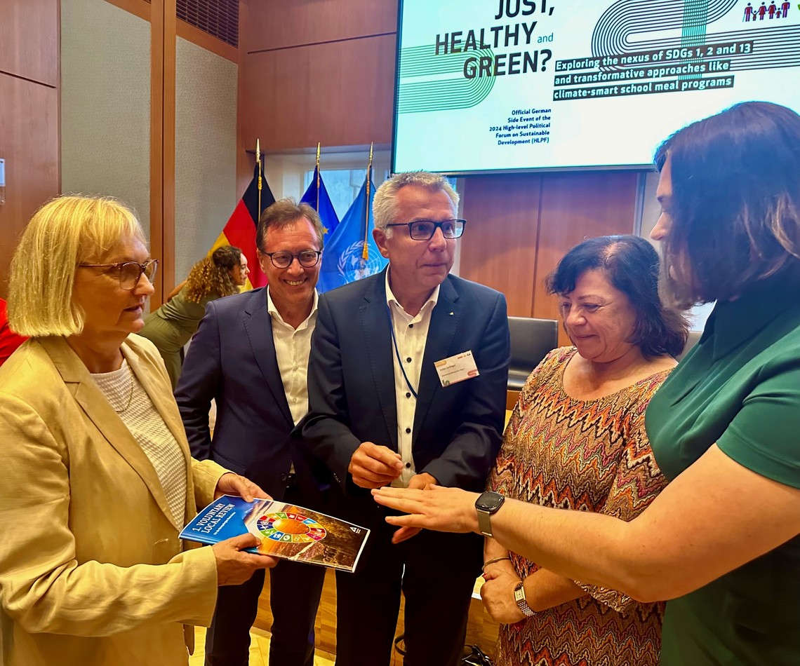 Fünf Personen in einem Konferenzraum sprechen miteinander während eine Person einen Bericht in der Hand hält. | © VRRN