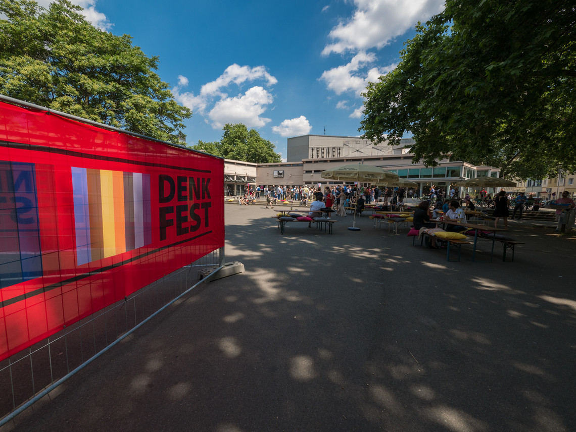 Ein Banner mit dem Denkfest Schriftzug an der Seite, im Hintergrund ein Gebäude | © Gunnar Fuchs