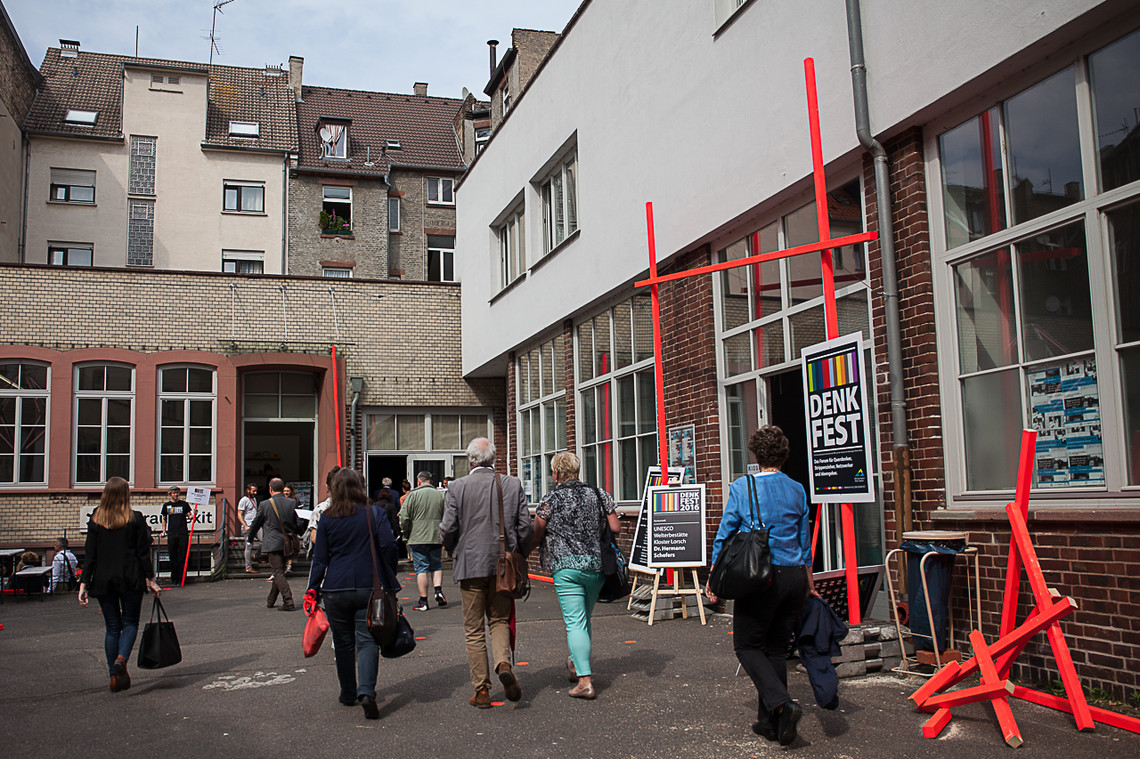 Mehrere Personen von hinten abgebildet, sie laufen auf ein Gebäude zu | © Sarah Ennemoser