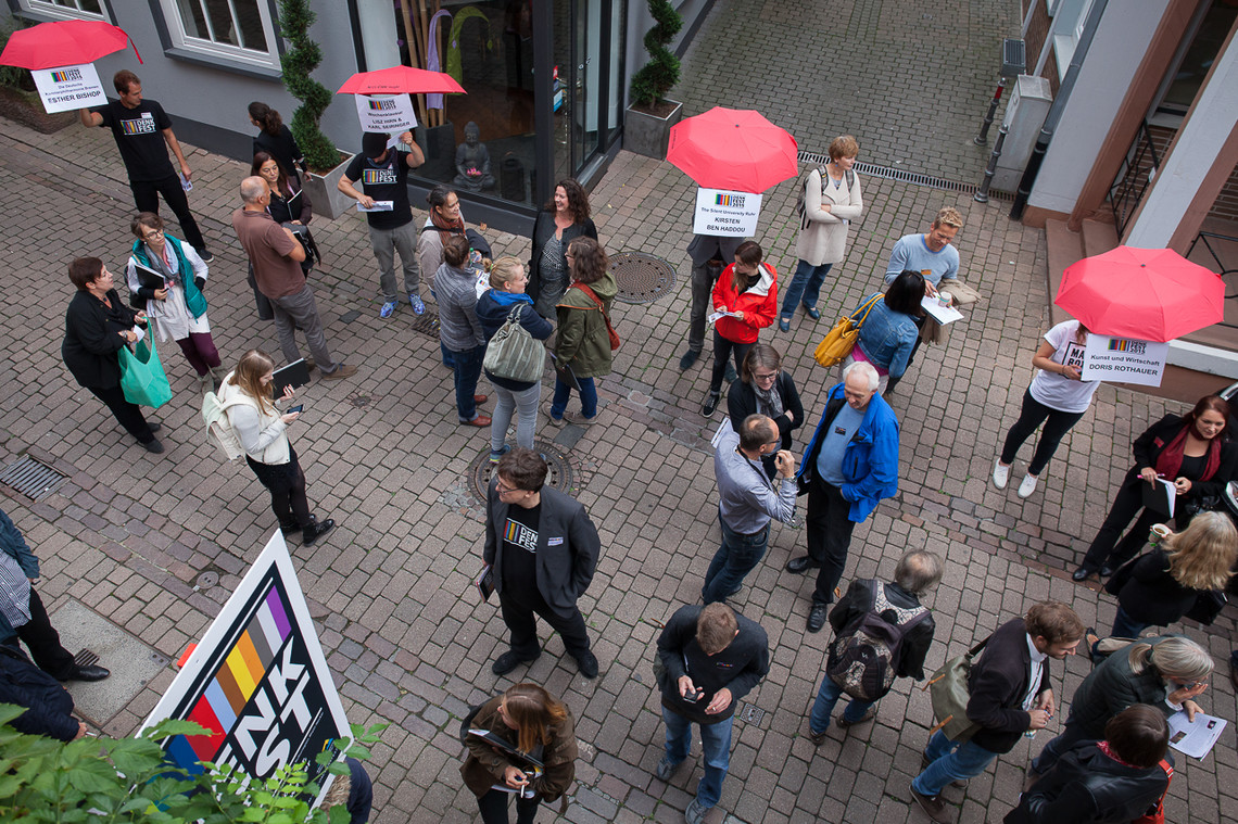 Mehrere Personen, teilweise mit Regenschirmen, von oben fotografiert.  | © Sarah Ennemoser