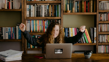 Mädchen vor Laptop reißt die Hände vor Freude in die Höhe | © MRN GmbH