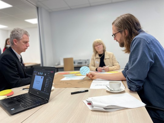 Menschen sitzen an einem Tisch mit Blättern und Stiften und diskutieren | © VRRN / LH