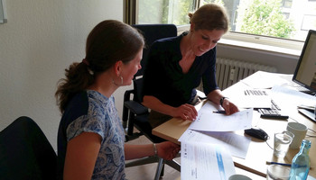 zwei Frauen sitzen am Schreibtisch und unterhalten sich | © Metropolregion Rhein-Neckar GmbH